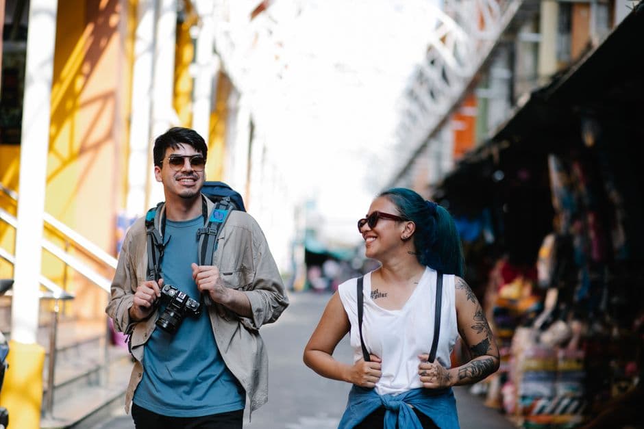 A cheerful couple with backpacks enjoying sightseeing during their travel adventure.